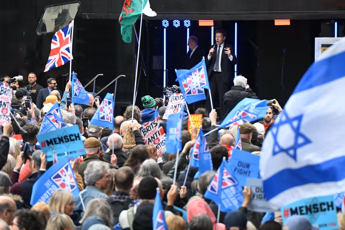 People holding blue and white Reform UK flags