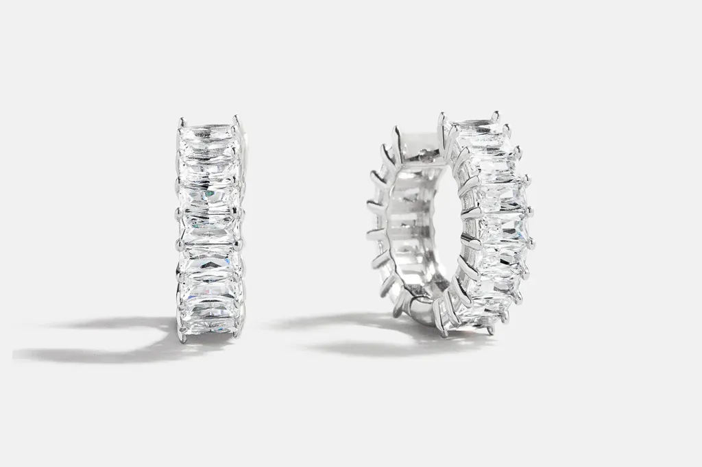 Two silver earrings with baguette-cut crystals.
