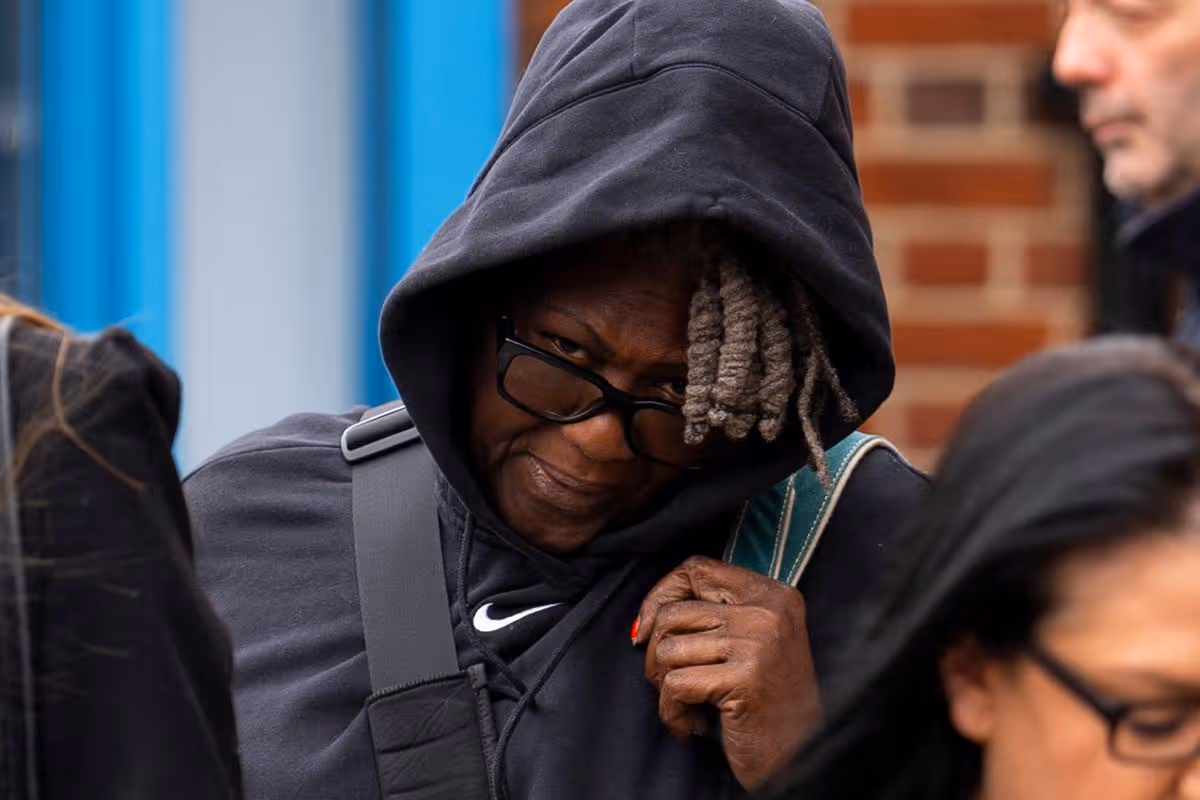 A photo of Nix outside court with a hood over her head