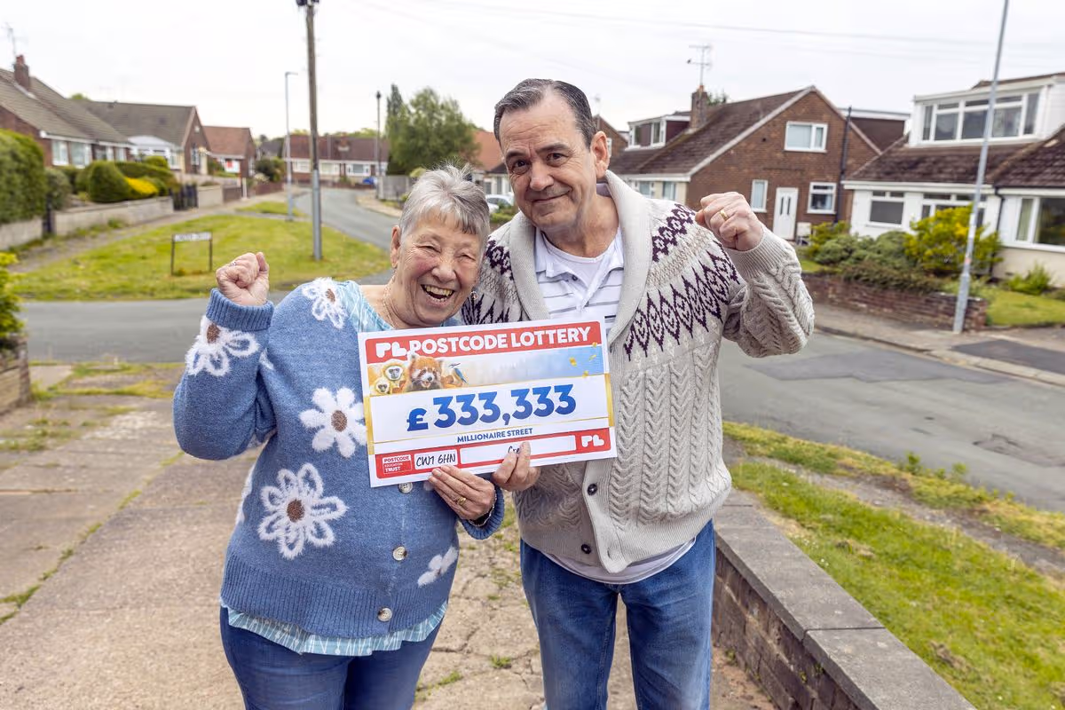 Nancy Barkley and her husband, Colin, holding a large cheque celebrating their £333,333 win