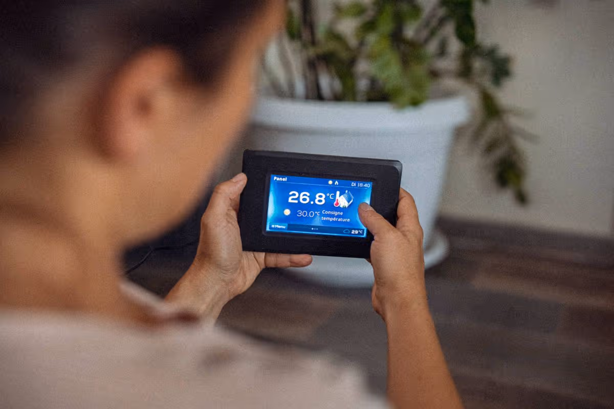 Using energy at home. Point of view of woman using smart control of the thermostat of heat pump, changing settings. Ease of use of artificial intelligence in everyday life