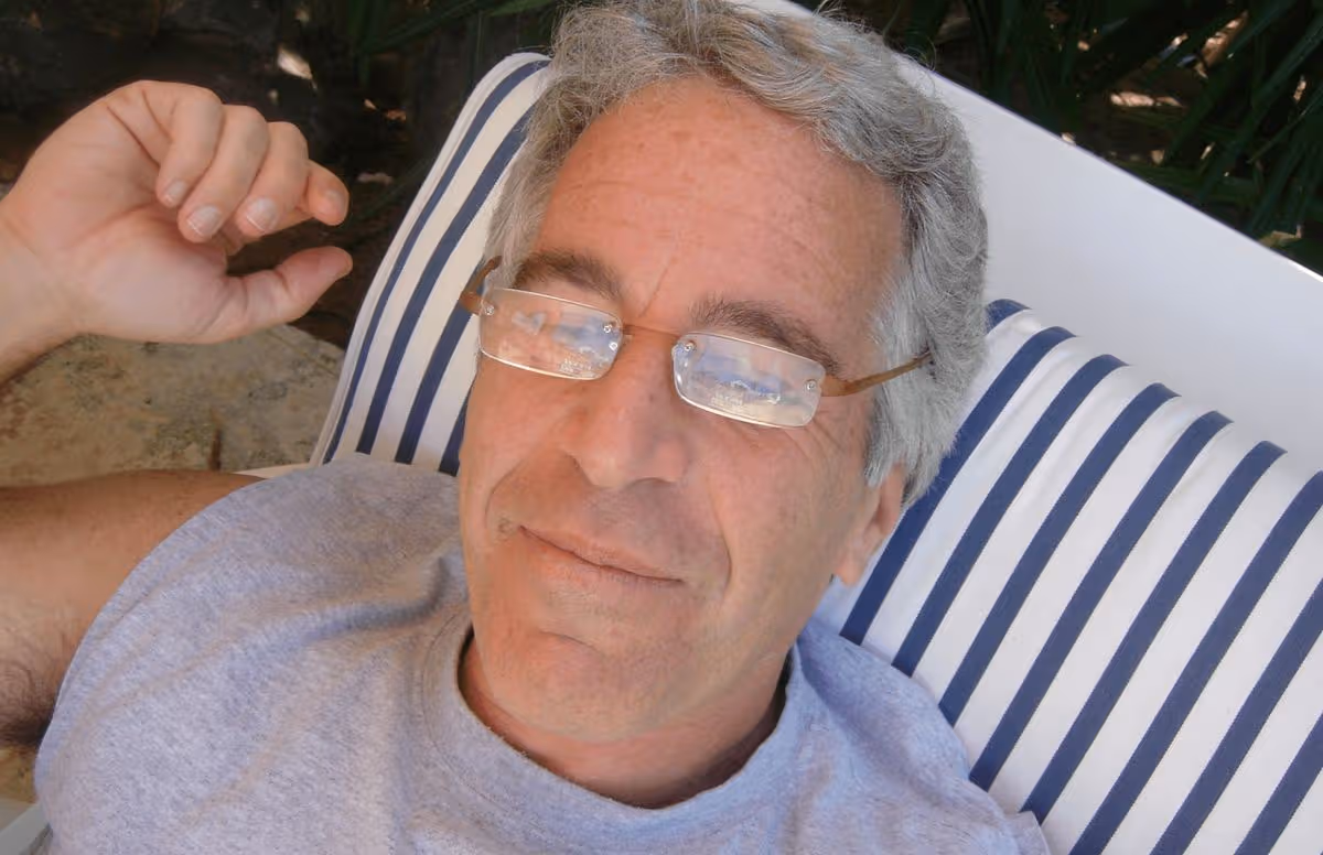 Jeffrey Epstein wearing glasses reclining on a sun bed