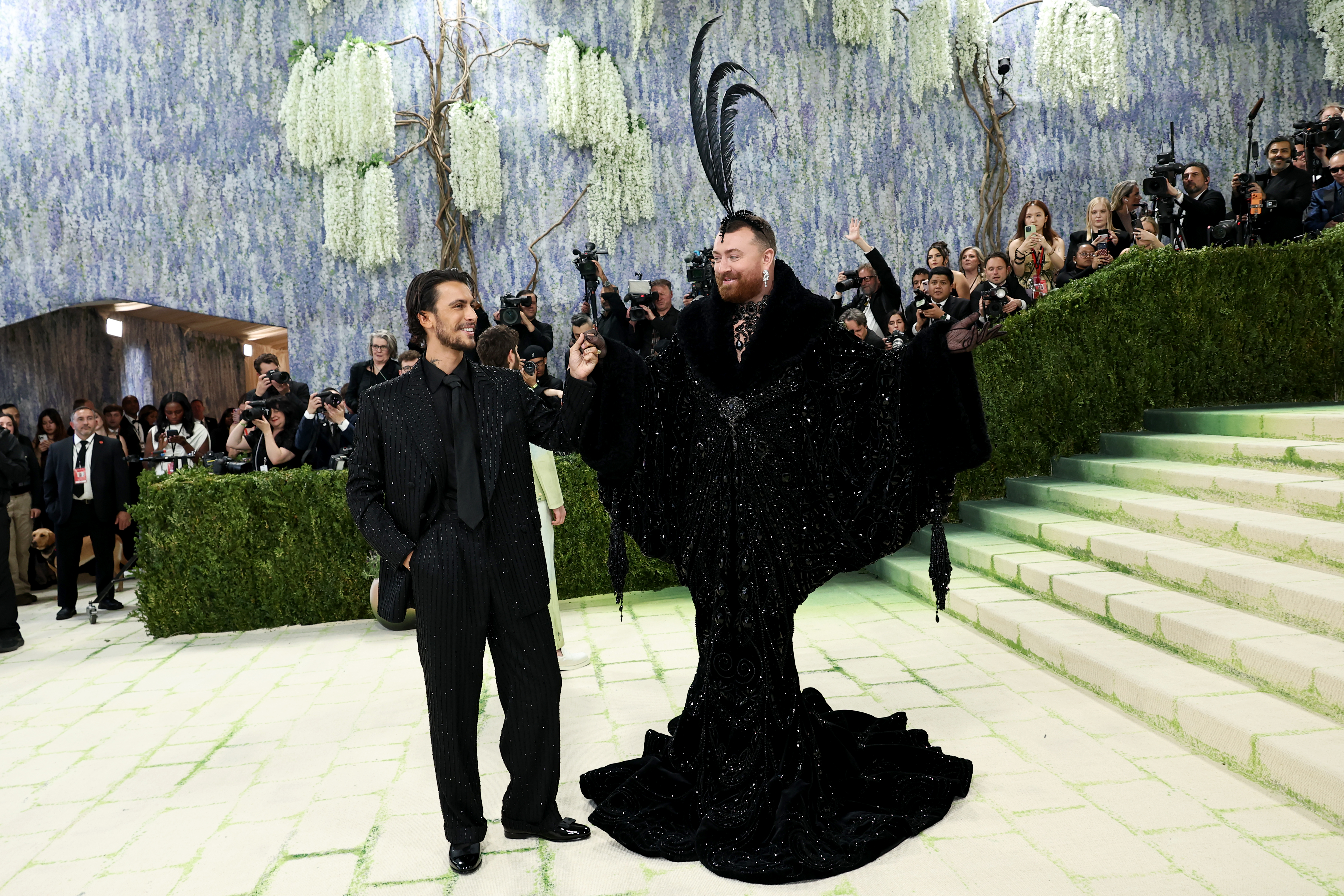 Christian Cowan in a black suit with Sam Smith in a dramatic black outfit at the Met Gala.