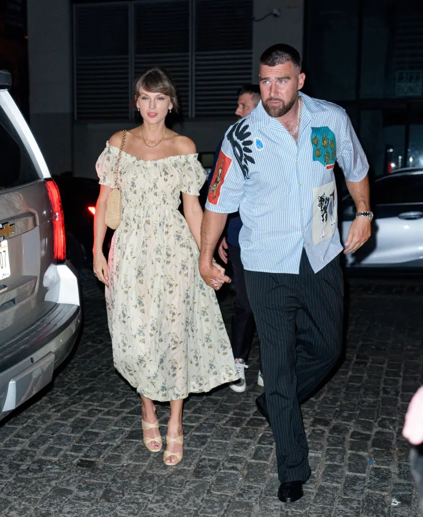 Taylor Swift and Travis Kelce holding hands while walking outside in New York City.