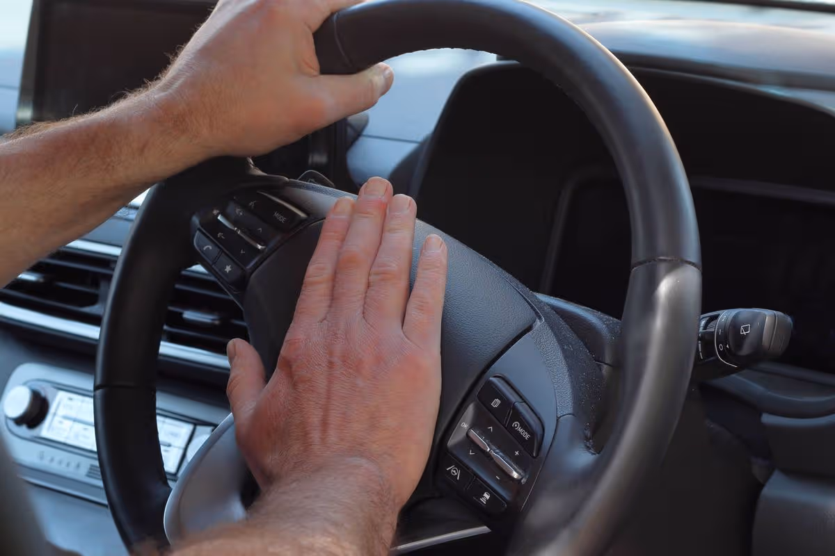 Close up of driver's hands honking horn