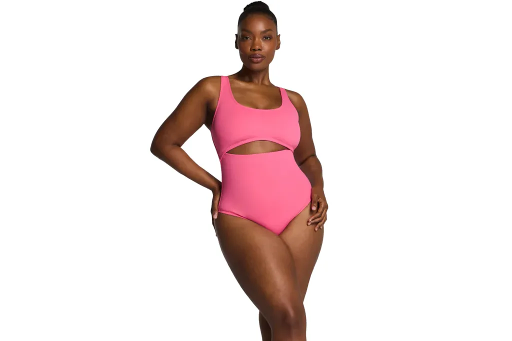 A woman in a pink one-piece swimsuit with a midriff cutout and square neck.
