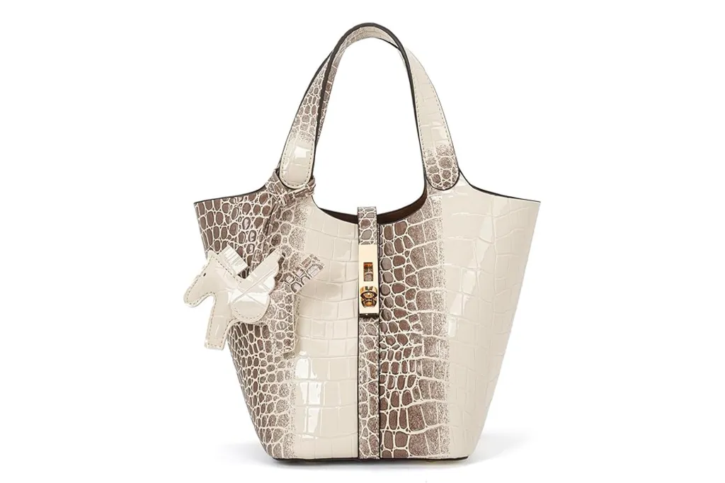 An off-white and brown crocodile-print handbag with a unicorn keychain.
