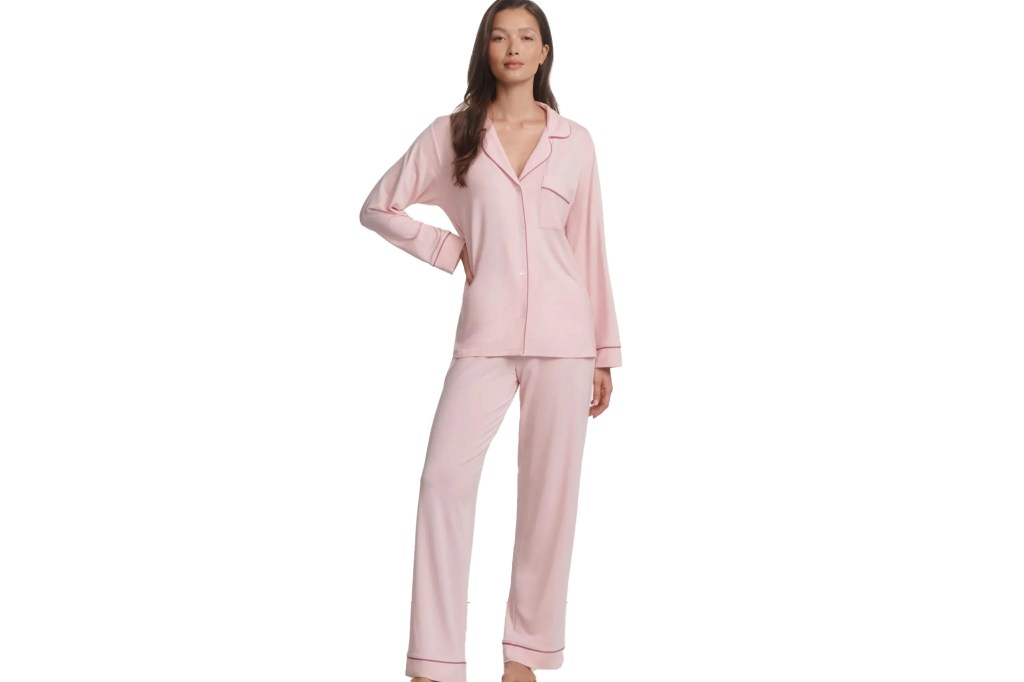 Woman wearing a light pink pajama set with dark pink piping.