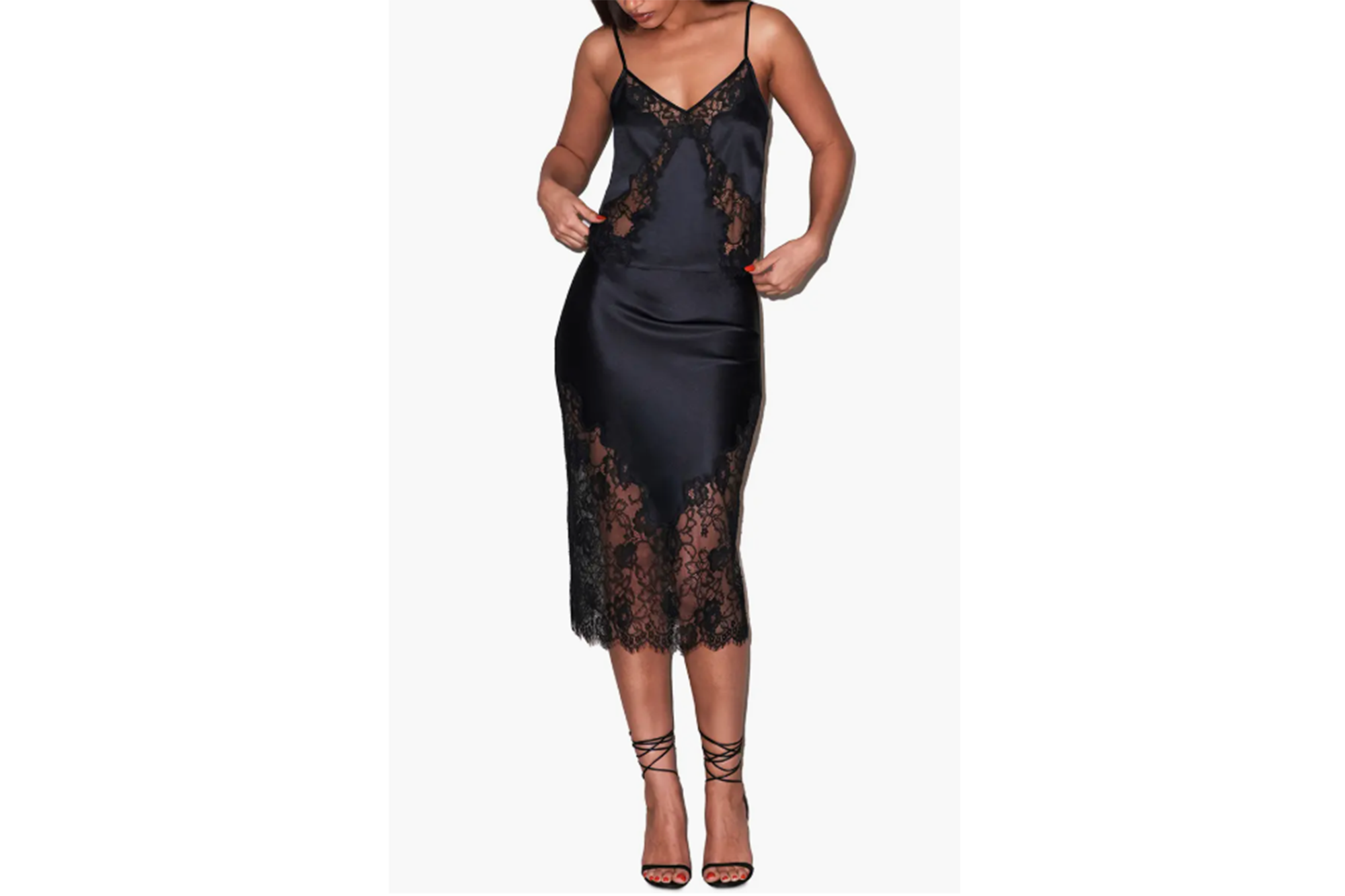 A woman wearing a black silk slip dress with lace trim.
