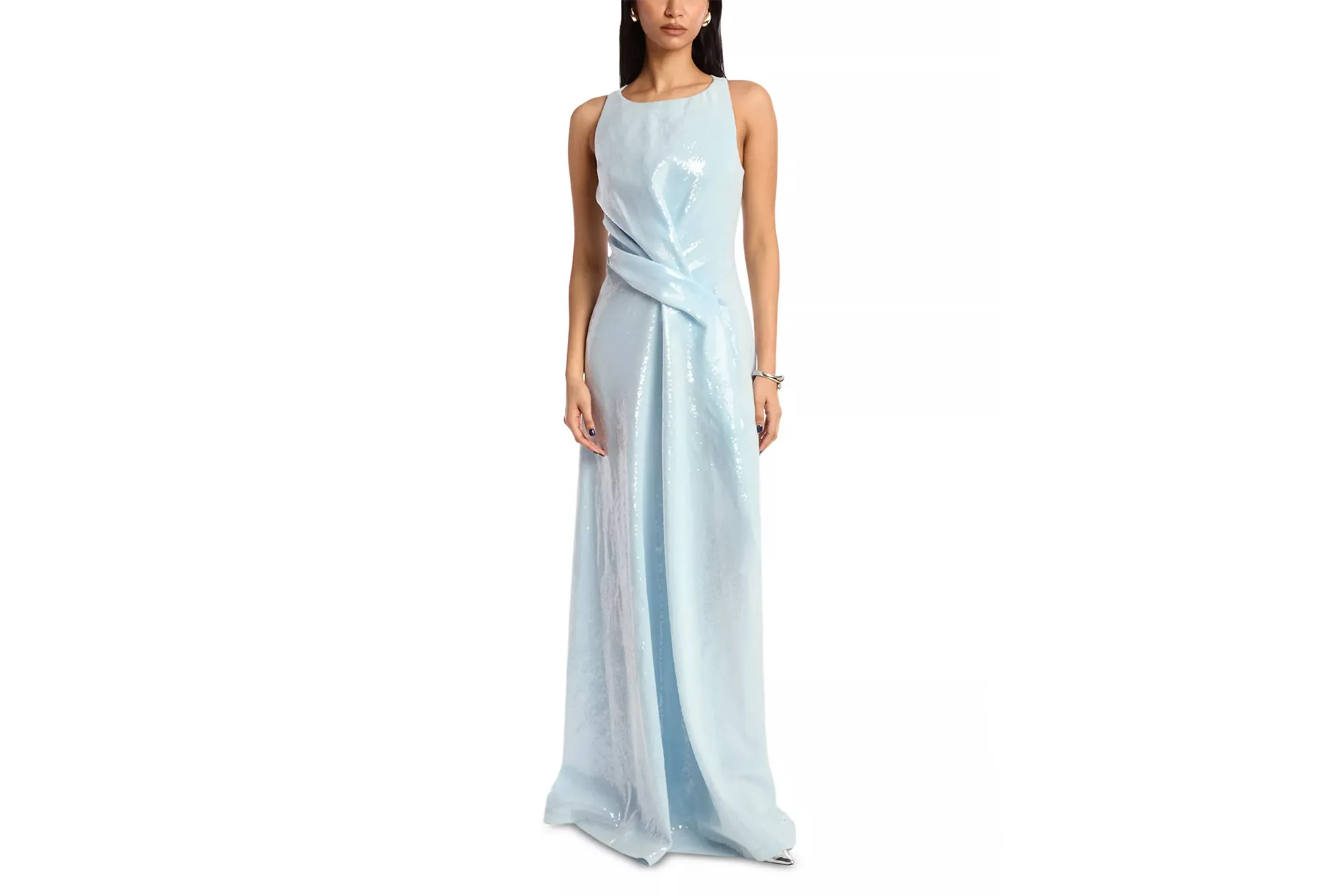A woman stands wearing a light blue, sequined, sleeveless gown with a diagonal ruched detail across the waist.