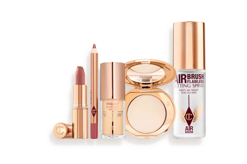 A kit of Charlotte Tilbury makeup products including lipstick, lip liner, Hollywood Flawless Filter, pressed powder, and Airbrush Flawless Setting Spray.
