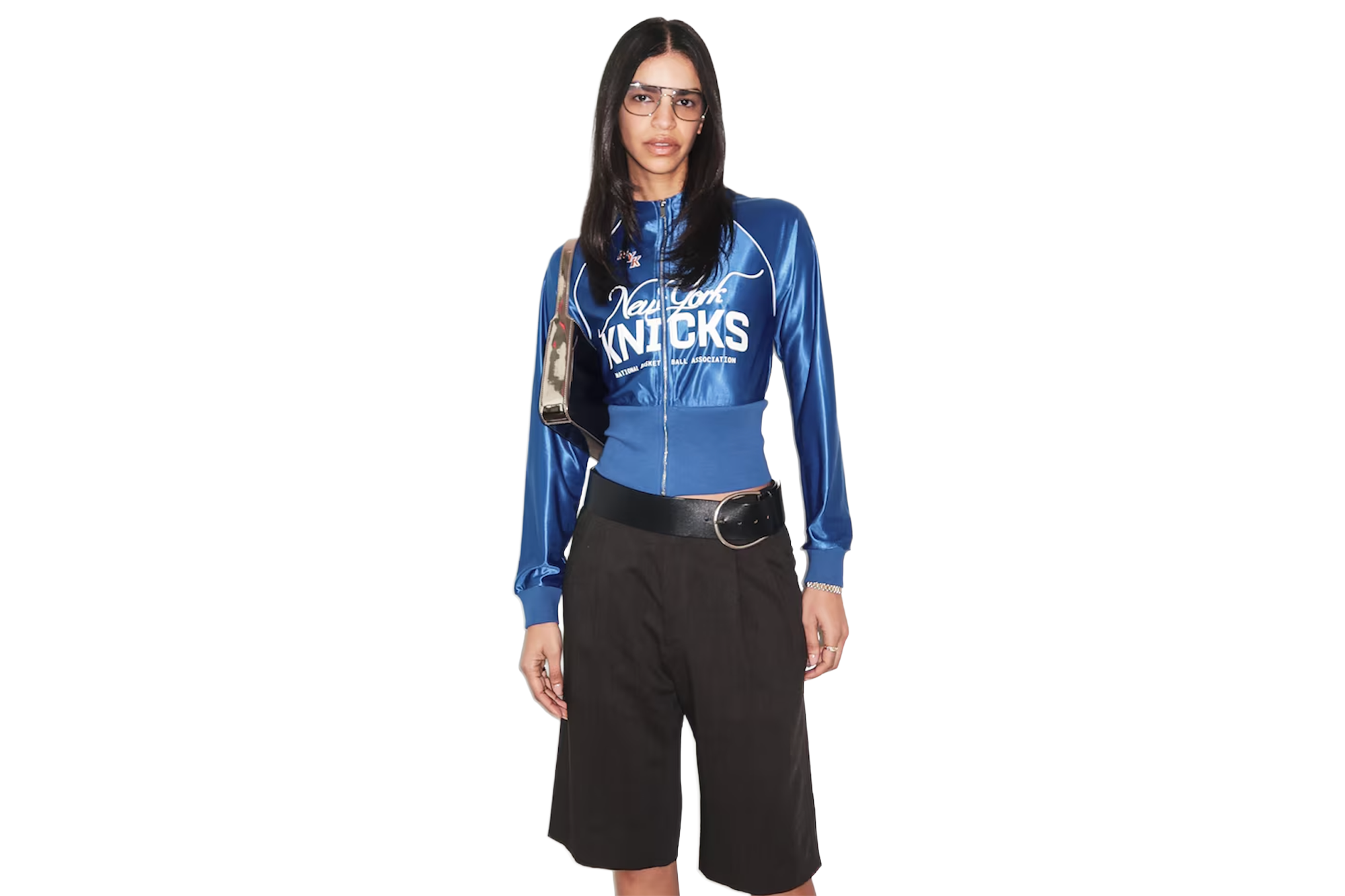 A woman wearing a blue New York Knicks jacket and dark shorts.