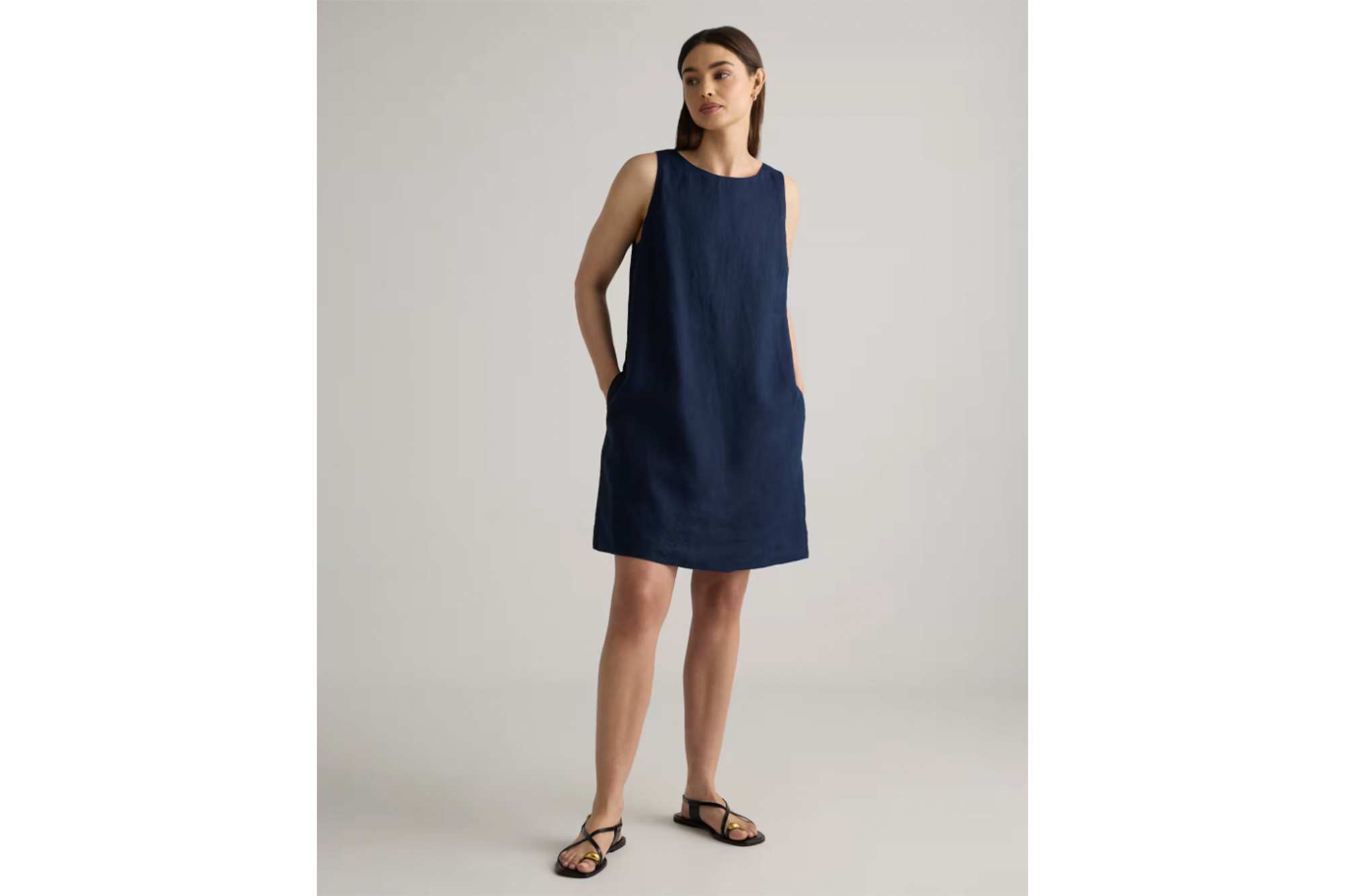 A woman models a navy sleeveless linen dress.