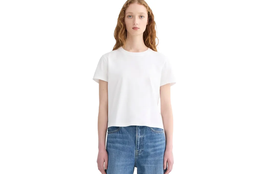 A white short-sleeved t-shirt on a model wearing blue jeans.