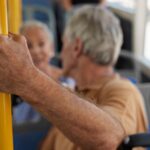 1774247314_0_Close-up-of-senior-man-holding-on-to-bar-on-public-bus.jpg