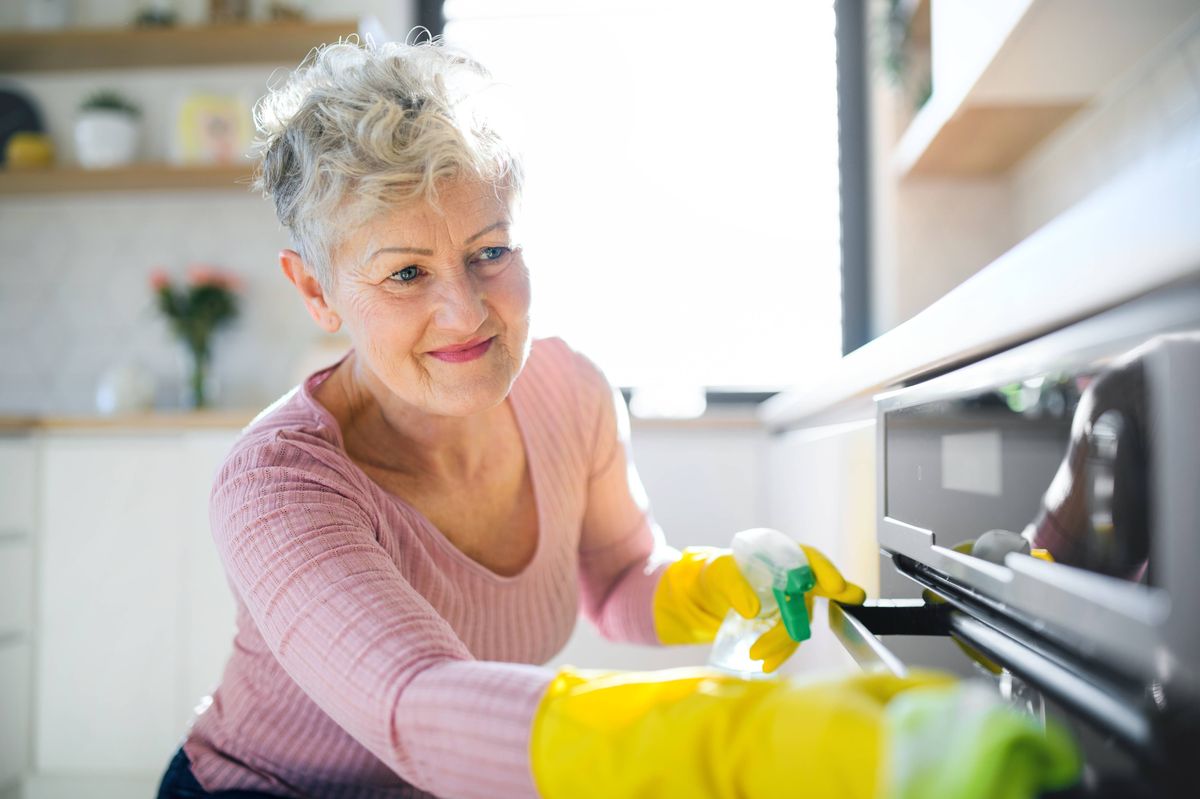 Happy older woman doing housework.