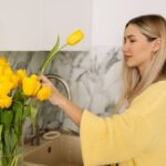 1775966786_0_A-beautiful-woman-with-long-hair-in-a-yellow-cardigan-is-pruning-flowers-at-home-changing-the-wate.jpeg