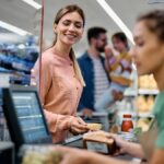 1776139937_0_Happy-woman-putting-groceries-on-checkout-counter-in-supermarket.jpg