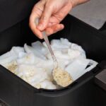 1777082601_0_Chef-adding-spices-to-squid-in-air-fryer-for-healthy-cooking.jpg