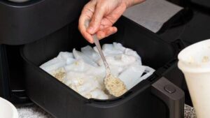 1777082601_0_Chef-adding-spices-to-squid-in-air-fryer-for-healthy-cooking.jpg